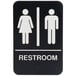 A black and white restroom sign with braille and white text for a man and woman.