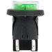 A close-up of a black and green Avantco power switch with a green light.