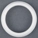 A white plastic circle with a white circle inside on a grey surface.