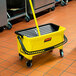 A yellow Rubbermaid mop bucket with a handle.