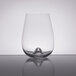A close-up of a Stolzle stemless wine glass with a small amount of liquid in it.