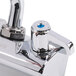 A chrome Equip by T&amp;S wall mount faucet with blue handles.