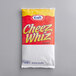 A red and white package of Kraft Cheez Whiz on a white background.
