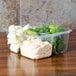 A Fabri-Kal clear plastic deli container with broccoli and cauliflower in it.