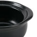 A Hall China black ceramic onion soup bowl with a lid.
