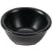 A Hall China black sauce dish on a white background.