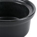 A black Hall China round casserole dish with a lid.
