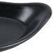 A Hall China black rarebit dish with a curved edge.
