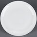 A CAC Majesty European bone china coupe plate with a white rim on a gray surface.