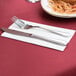 A knife and fork on a white napkin.