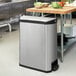 A Rubbermaid stainless steel rectangular trash can with black accents.