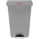 A grey Rubbermaid Slim Jim rectangular trash can with a red label.