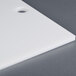 A white plastic filler plate for a vacuum packaging machine with holes.
