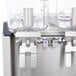 A stainless steel Crathco Mini-Quad refrigerated beverage dispenser with four bowls.