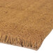 A Cactus Mat natural tan scraper mat with fringes on it.