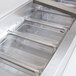 A stainless steel Avantco refrigeration pan divider bar on a counter.