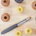 A black Victorinox apple/cupcake corer with a knife and a group of small cupcakes.