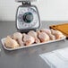 A white foam CKF meat tray with raw chicken legs on a kitchen counter.