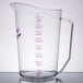 A clear Cambro polycarbonate measuring cup with a handle and purple measuring scale.