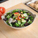 A bowl of salad with vegetables in a Thunder Group Jazz melamine bowl.