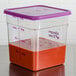 A clear Cambro CamSquares food storage container with a purple lid containing red liquid.