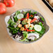 A Thunder Group Jazz melamine bowl filled with salad on a table with a tomato on top.