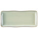 A rectangular white china tray with a light green and gold trim.