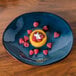 A Tuxton TuxTrendz Artisan Night Sky china ellipse plate with a dessert on it.