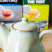 A Tuxton Artisan Sagebrush teapot with lid on a table.