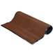 A roll of chocolate brown carpet with black trim on the edges.