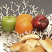An Eastern Tabletop cast aluminum branch display tray with a bowl of fruit and bread on a table.