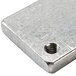 A metal square with a screw hole and a screw.
