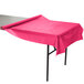 A Creative Converting hot magenta pink plastic table cover on a table.