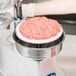 A Globe PP4 Patty Press with raw meat on a plate.