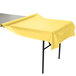 A Mimosa yellow plastic table cover on a table with a yellow tablecloth.