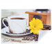 A coffee cup and a yellow flower on a Hoffmaster Good Morning paper placemat.