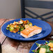 A piece of salmon and brussels sprouts on a Fiesta® Lapis blue chop plate.