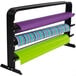 A Bulman black countertop rack holding three rolls of multi colored wrapping paper.