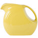 A yellow Fiesta pitcher with a yellow handle.