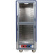 A blue Metro C5 holding and proofing cabinet with clear Dutch doors and shelves on wheels.