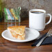 A white Fiesta® appetizer plate with a slice of pie on it next to a mug of brown liquid.