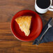 A piece of pie on a Scarlet Fiesta® appetizer plate next to a cup of coffee.