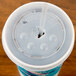 A Solo translucent plastic lid with straw slot and identification buttons on a plastic cup with a straw.