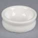 A white Tuxton china bowl on a gray surface.