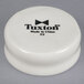 A white Tuxton round china dish with black text reading "Tuxton" on it.