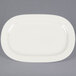 A white Tuxton oval china platter with a small rim.