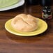 A Fiesta® round china bread and butter plate with a bread roll on it.
