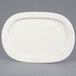 A white Tuxton oval china platter with a small rim.