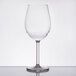 A clear Tritan wine glass with a stem on a reflective surface.
