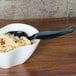 A bowl of pasta with a Fineline black plastic serving spoon in it.